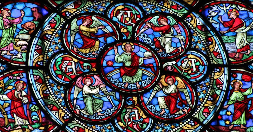 Vibrant stained glass window depicting biblical scenes and figures in a church.